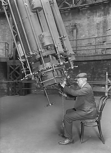 circa 1915 picture of man using big telescope
