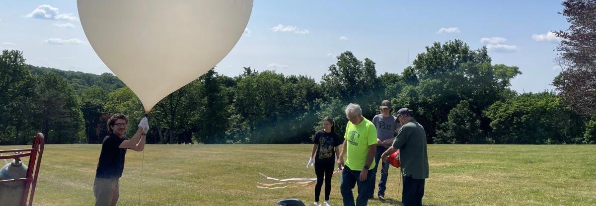 People preparing small weather balloon